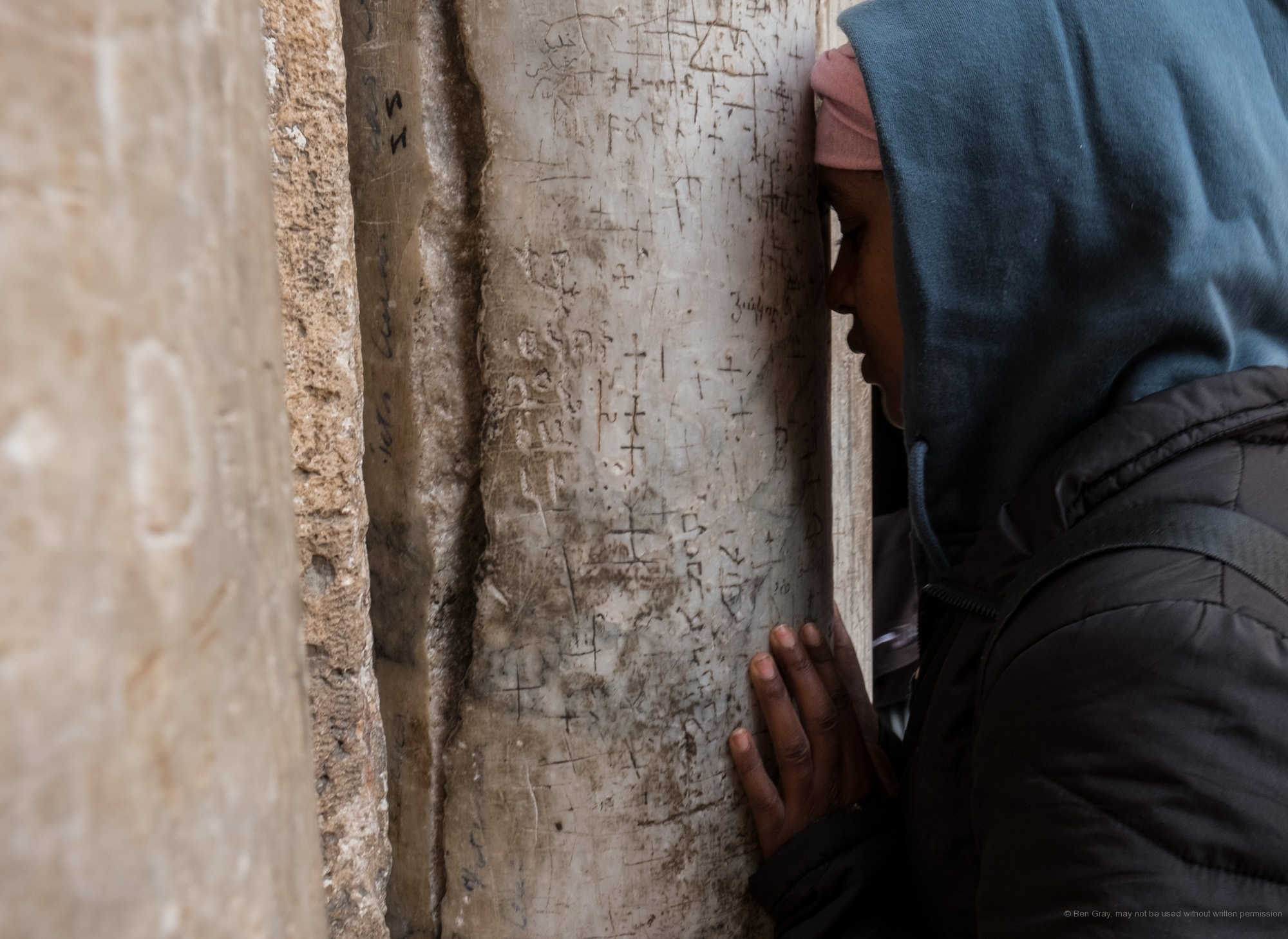 A woman stops to pray at the entrance to the Church of the Holy Sepulchre.