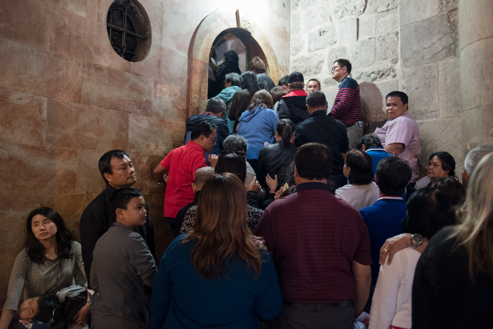 A crowd of pilgrims presses into the stairwell that leads to Calvary.