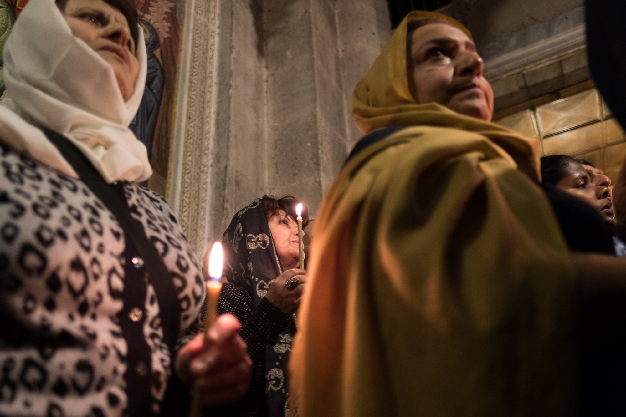 A group of women process by candlelight in an Armenian ceremony.