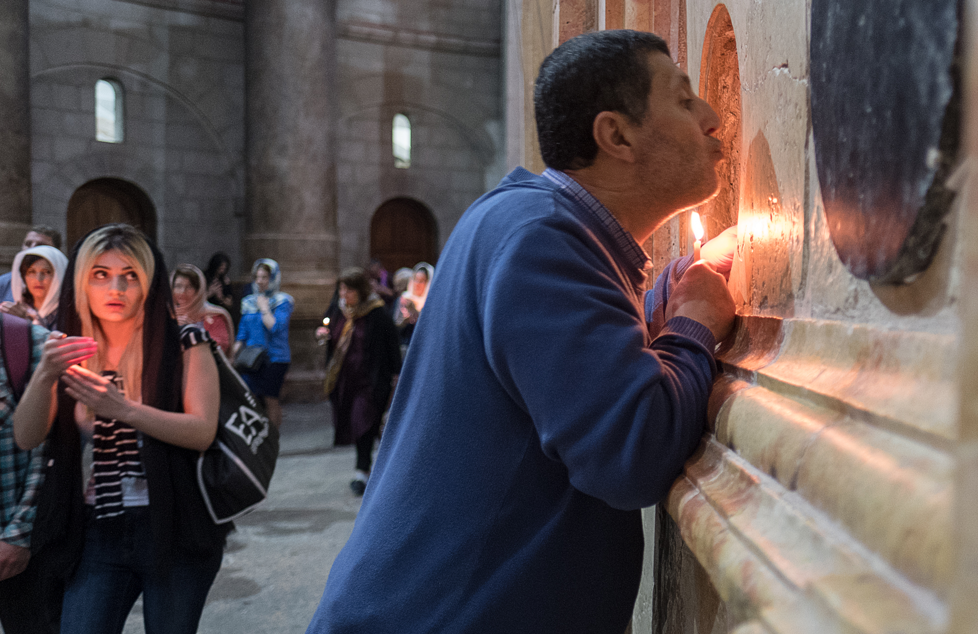 A man stretches to kiss the Edicule, which houses Jesus' tomb within the Church of the Holy Sepulchre.