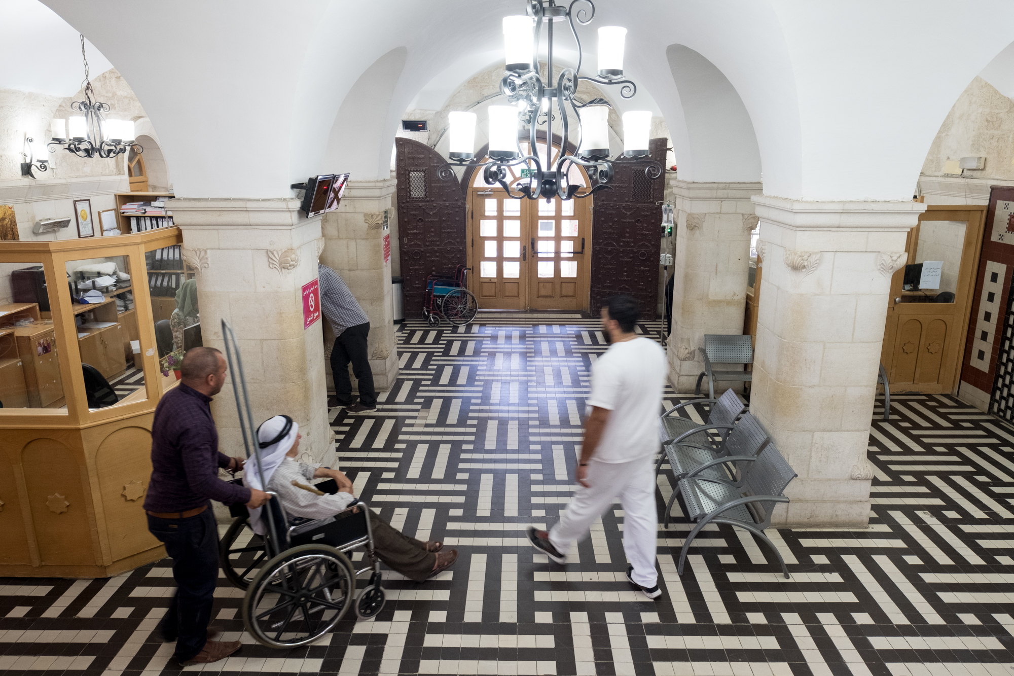 Patients and staff make their way through the lobby of The Lutheran World Federation's Augusta Victoria Hospital (AVH) in East Jerusalem on Saturday morning, 8 September, 2018. AVH is the only hospital that offers radiation treatments for cancer and pediatric hemodialysis for Palestinians from the West Bank and Gaza. Photo by Ben Gray / LWF