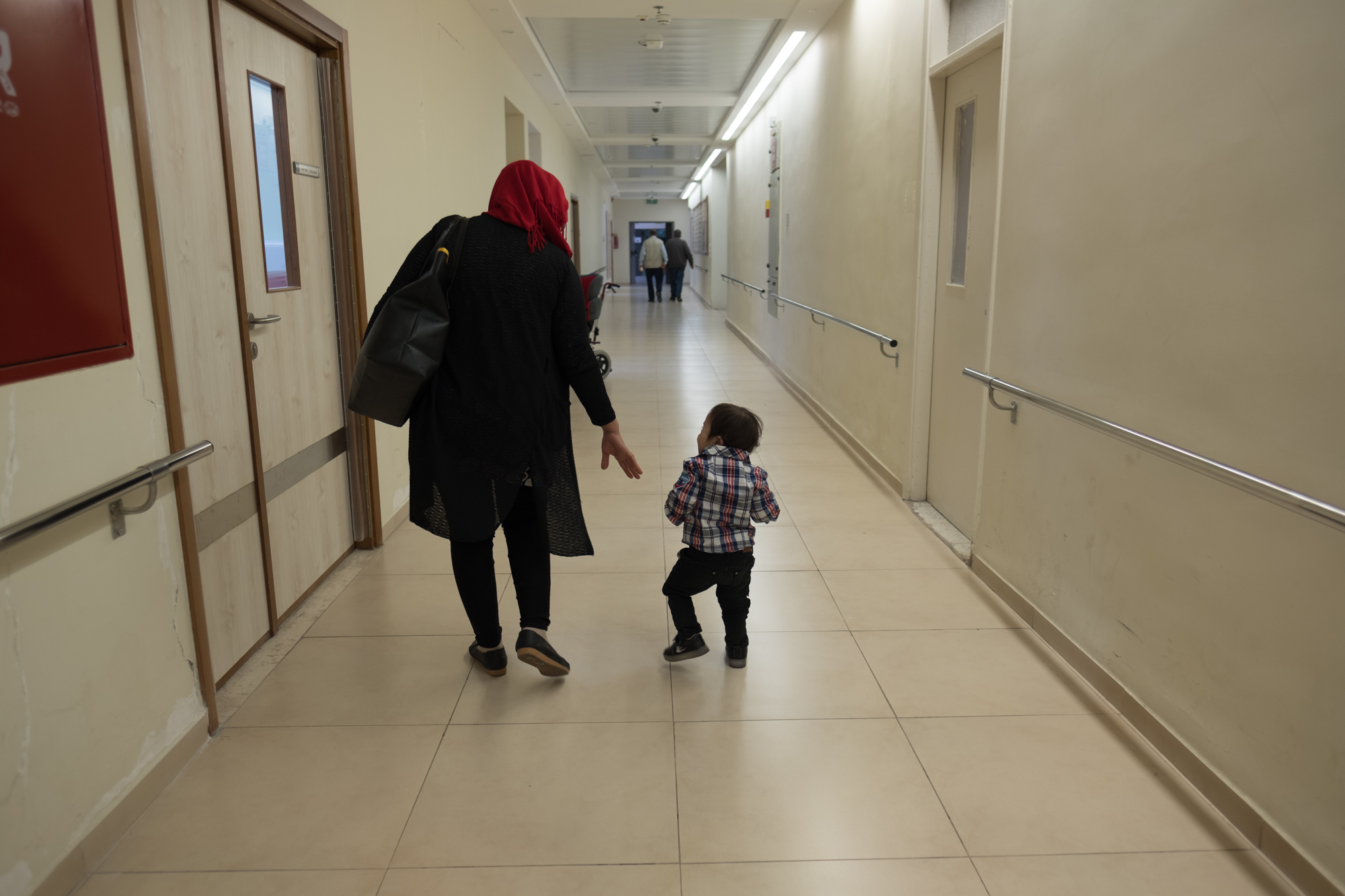 Anas, a two-year-old with downs syndrome, heads down the hall with his mother after occupational therapy at the Jerusalem Princess Basma Center, on Tuesday, 30 October, 2018. Photo by Ben Gray / LWF