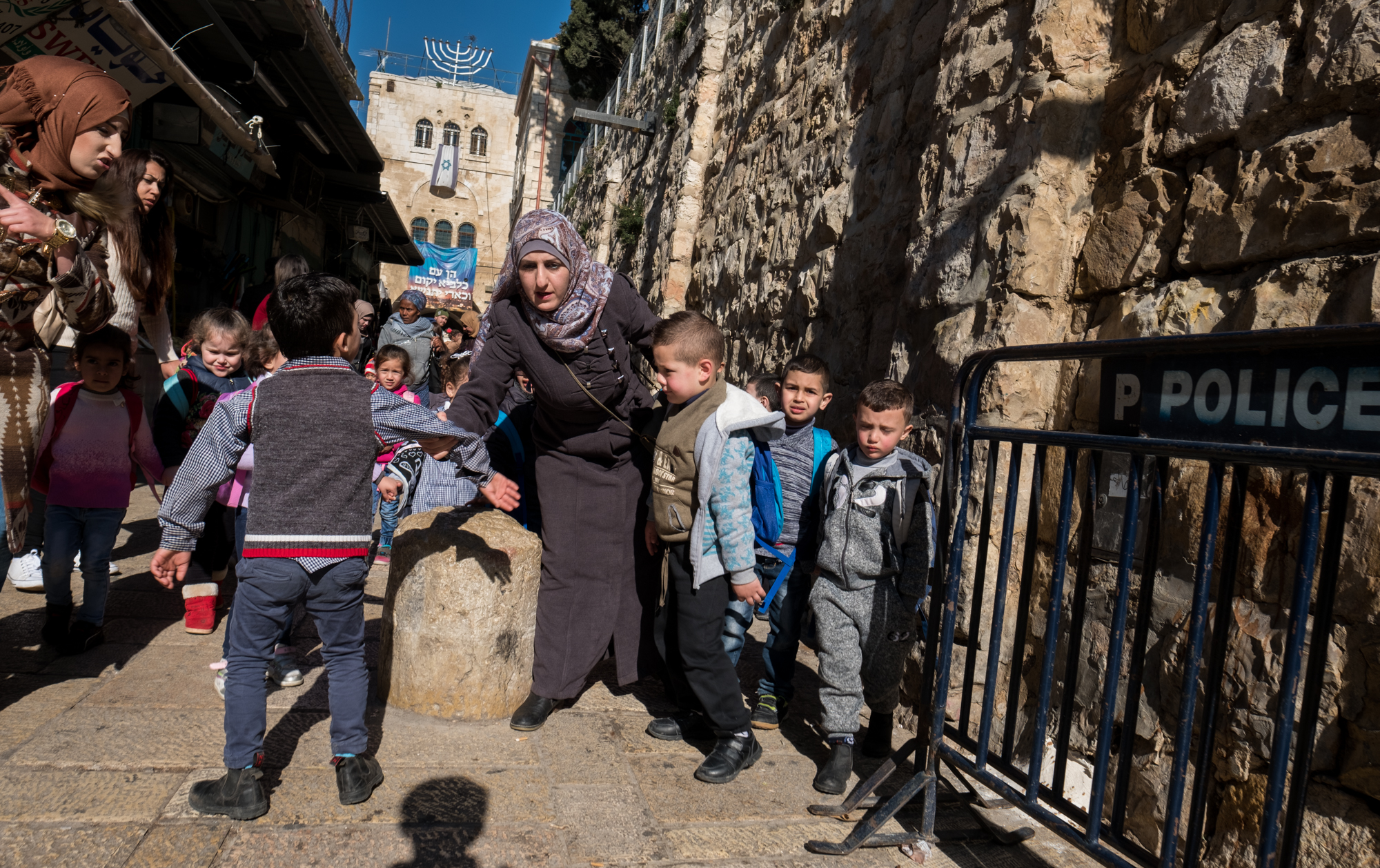 A Palestinian teacher tries to keep her students in line as they walk on the Via Dolorosa in Jerusalem's Old City.