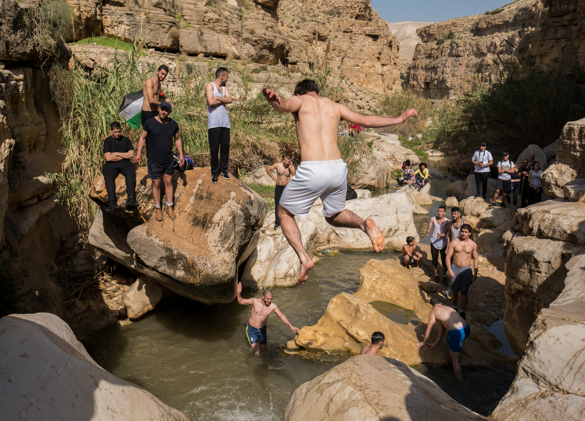 Palestinians stop to swim and play while hiking through a valley in the West Bank.