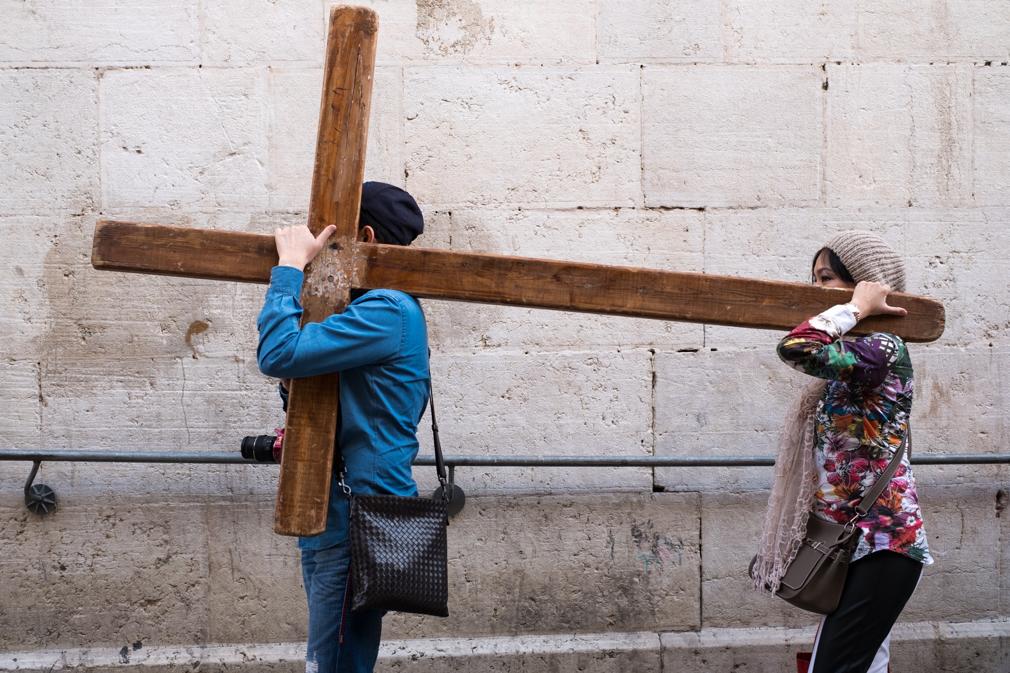 Pilgrims shoulder a cross as they follow the Via Dolorosa.