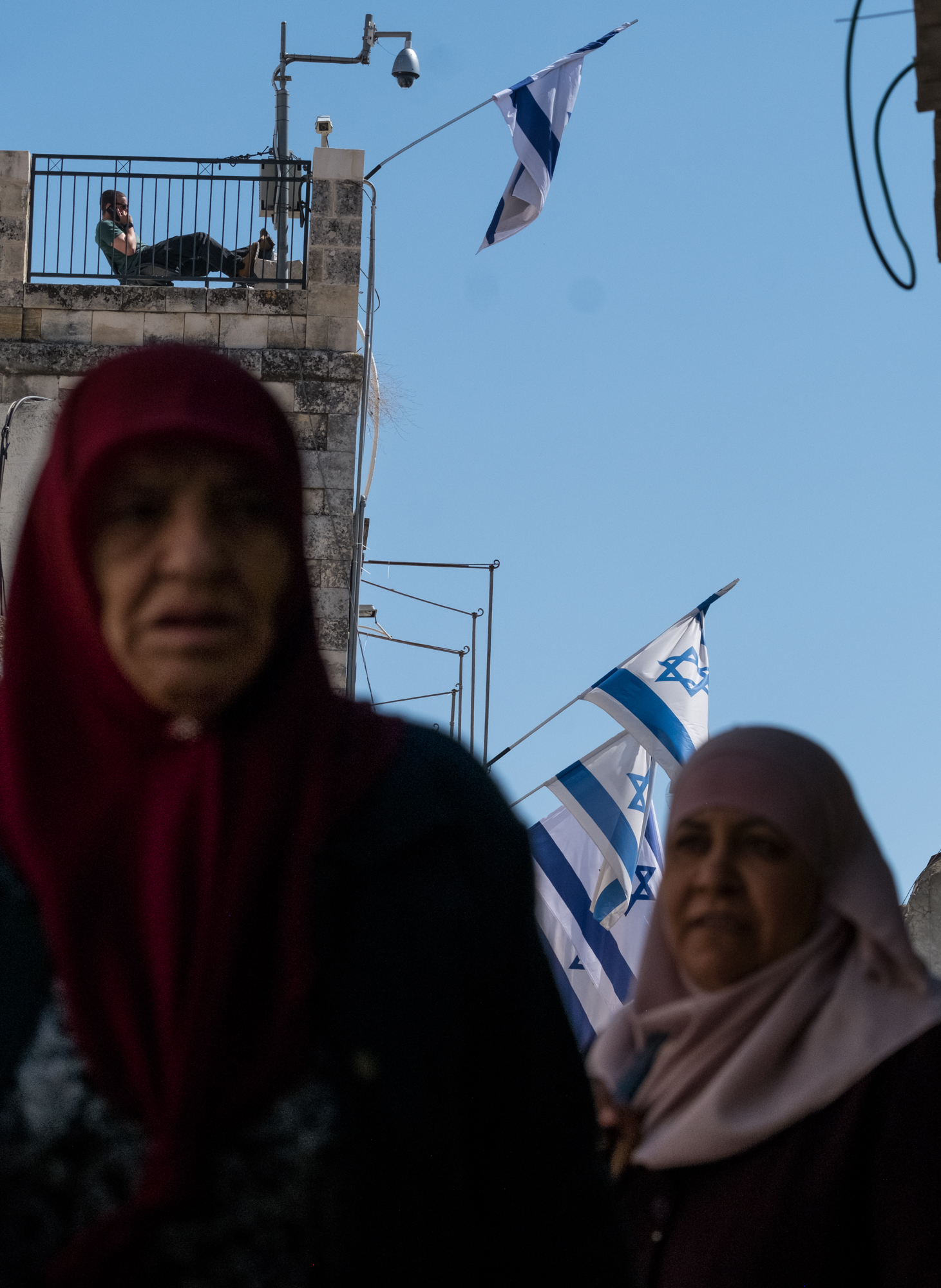 Palestinian women walk under a Jewish pocket settlement in Jerusalem's Old City.