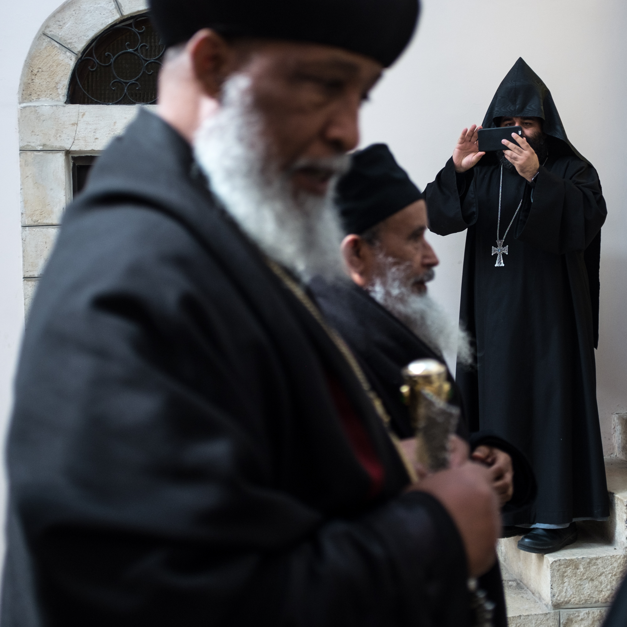 An Armenian monk photographs guests as they depart from a Christmas gathering.