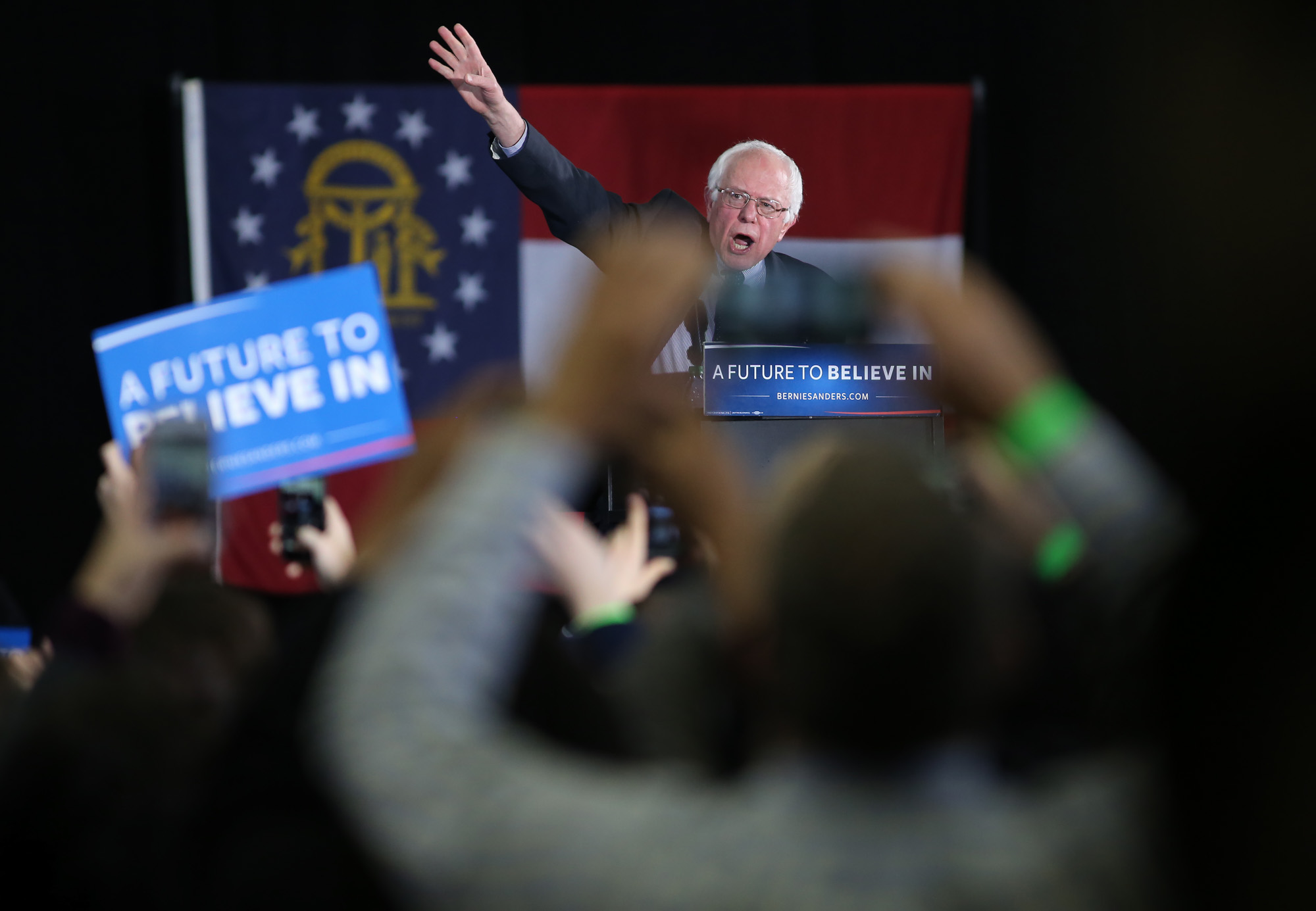 Bernie Sanders waves to the crowd as he takes the podium at his campaign rally at Morehouse College.