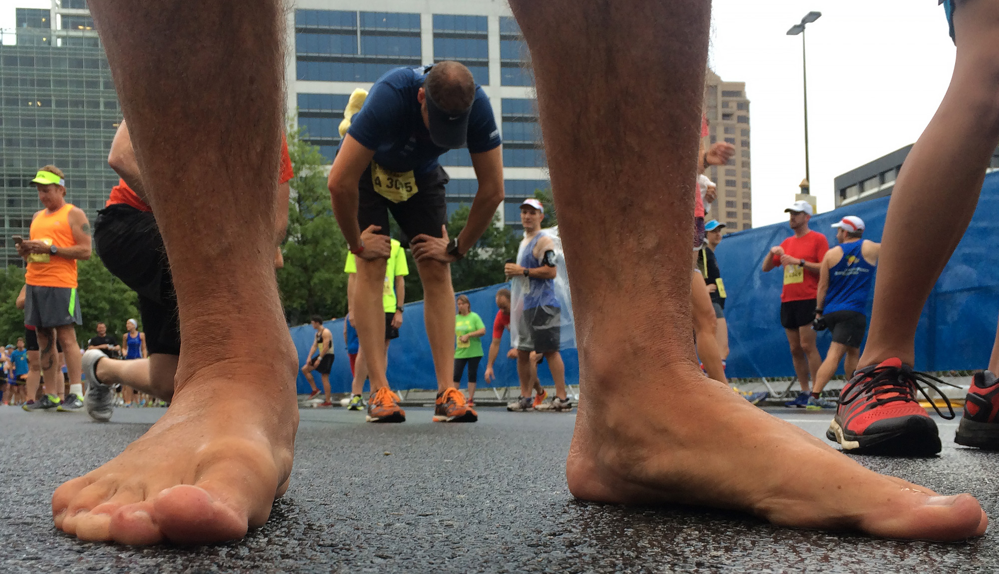 Gerry Burke of Duluth waits with the A wave before running the AJC Peachtree Road Race barefoot on Saturday.