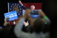 Bernie Sanders waves to the crowd as he takes the podium at his campaign rally at Morehouse College.