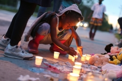 Samarah Bagby, 8, stares at a candle during a vigil for Isaiah Ward, who was hit and killed while walking on the sidewalk with his brother.