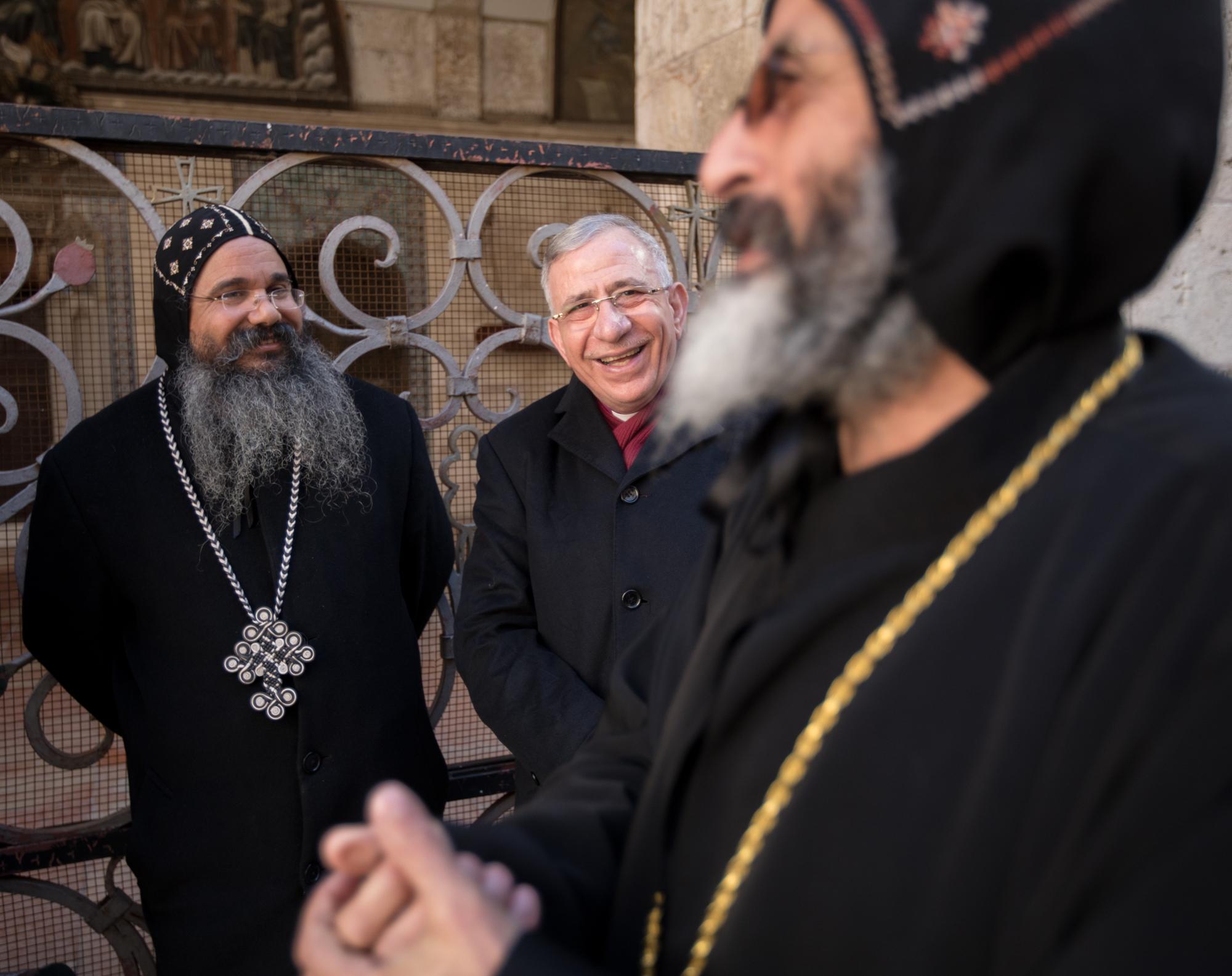 Bishop Dr. Munib Younan jokes with Coptic monks during a Christmas gathering.