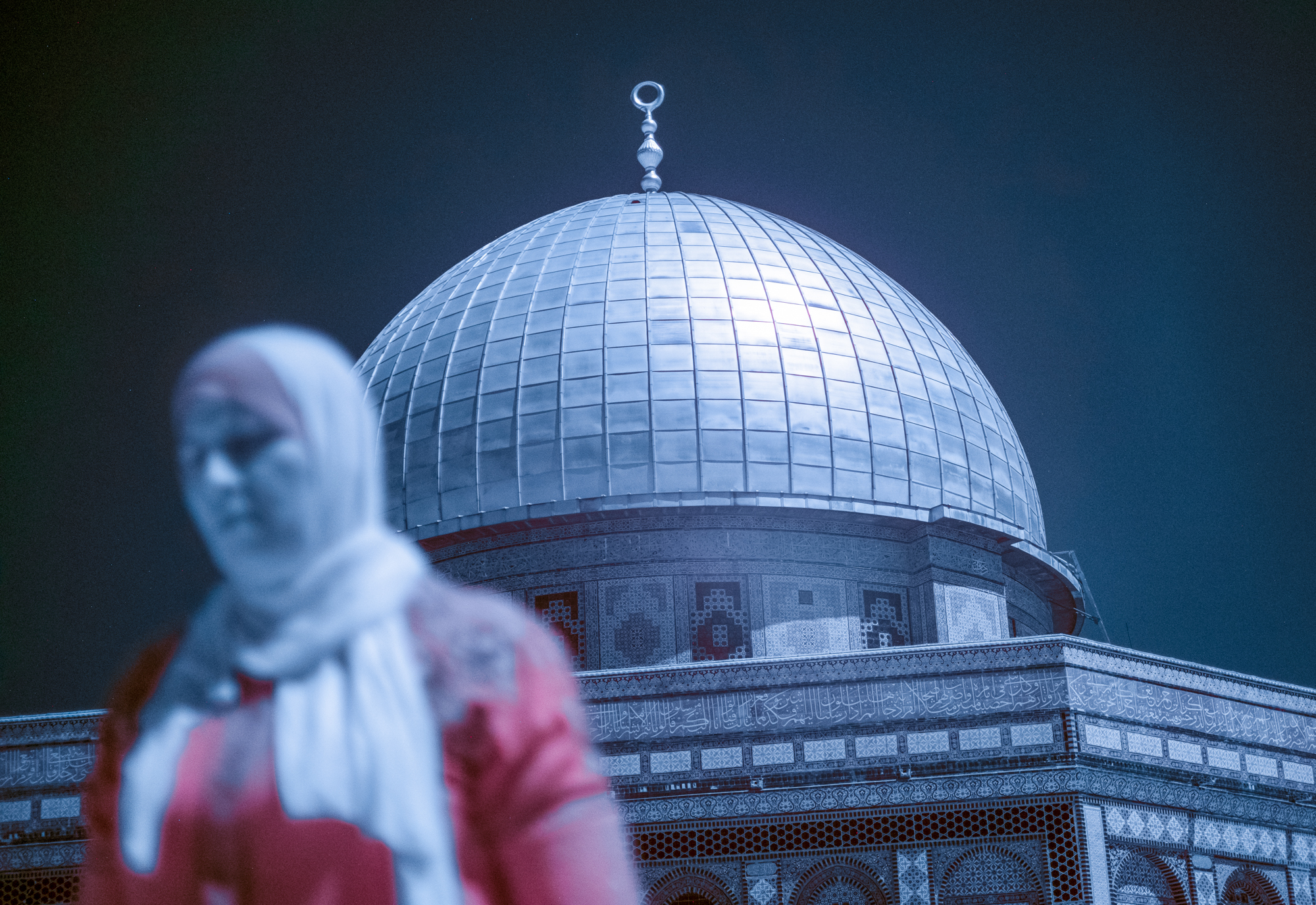 A woman walks past the Dome of the Rock, one of the holiest sites in Islam.