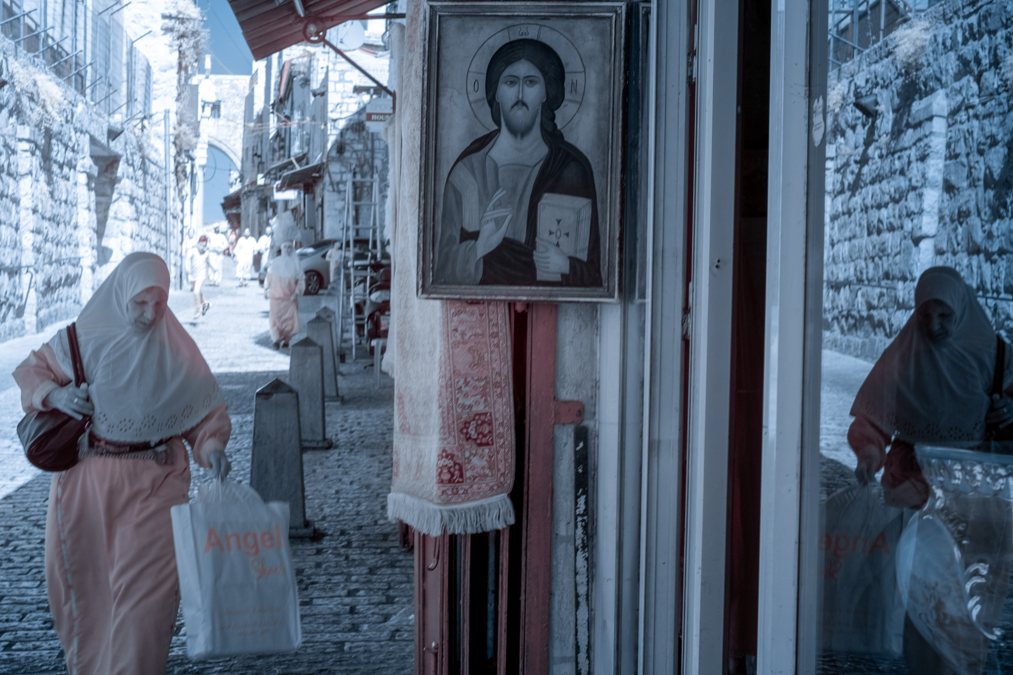 A Muslim woman walks past an icon of Jesus as she walks on the Via Dolorosa, the path Jesus was believed to have walked to his crucifixion.