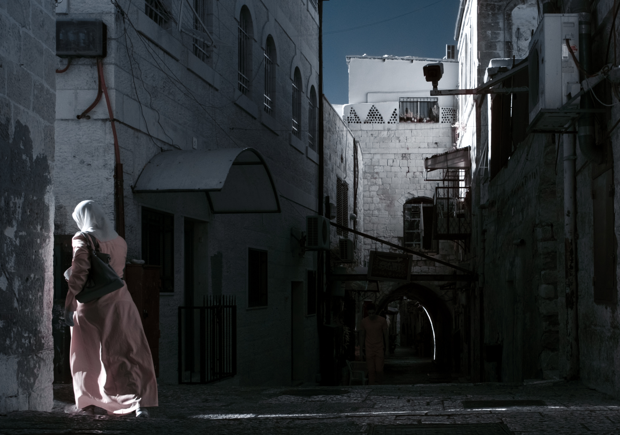 A  woman turns down an alley in the Muslim quarter of Jerusalem's Old City.